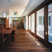 view of the living and dining aarea featuring daylighting, floor, flooring, hardwood, home, house, interior design, real estate, window, wood, wood flooring, gray, black