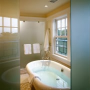 view of this bathroom featuring freestanding kohler bathtub, architecture, bathroom, bathtub, ceiling, daylighting, estate, floor, home, house, interior design, property, real estate, room, wall, window, brown