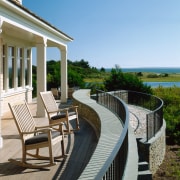 view of this cape cod home situated on deck, estate, outdoor furniture, outdoor structure, patio, property, real estate, walkway, teal