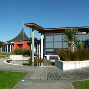 Exterior of Massey Library showing water feature, timber architecture, cottage, estate, home, house, property, real estate, residential area, villa, water, teal