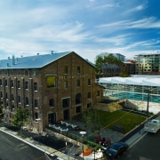 Large brick building called The Cooperage, with pool architecture, building, city, commercial building, condominium, corporate headquarters, headquarters, metropolitan area, mixed use, neighbourhood, real estate, residential area, roof, urban area, urban design, black