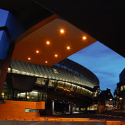 An exterior view of the building. - An architecture, building, city, downtown, evening, landmark, light, lighting, metropolis, metropolitan area, night, performing arts center, reflection, sky, structure, black