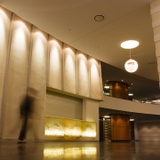 Large apartment lobby area featuring limestone-clad walls and architecture, ceiling, daylighting, interior design, light, lighting, lobby, brown