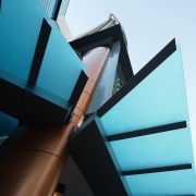 Artistic features at entrance to apartment building. angle, architecture, blue, building, daylighting, daytime, facade, glass, line, product design, sky, structure, black, teal, white