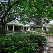 An exterior view of the driveway and entrance architecture, backyard, cottage, estate, farmhouse, garden, historic house, home, house, mansion, neighbourhood, outdoor structure, plant, plantation, property, real estate, residential area, tree, yard, green