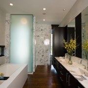 view of this bathroom featuring timber flooring, bathrub, architecture, bathroom, ceiling, countertop, home, interior design, real estate, room, gray