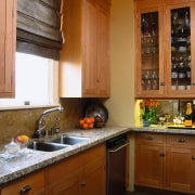 view of the kitchen featuring granite countertop, maple cabinetry, countertop, cuisine classique, home, interior design, kitchen, room, under cabinet lighting, window, brown