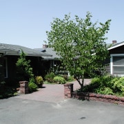 view of the exterior of this river side cottage, estate, home, house, landscape, neighbourhood, plant, property, real estate, residential area, suburb, tree, walkway, yard, gray