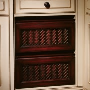 A view of a kitchen by NuHaus Custom cabinetry, chest of drawers, drawer, furniture, home appliance, kitchen appliance, kitchen stove, major appliance, oven, shelving, wood stain, orange, red