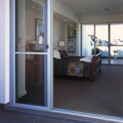 A view of the patio area. - A door, floor, flooring, glass, real estate, window, gray