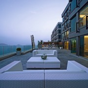 An exterior view of the patio area. - apartment, architecture, building, condominium, home, house, mixed use, real estate, sky, water, teal, blue