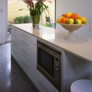 A view of the kitchen area, concrete flooring, cabinetry, countertop, home appliance, interior design, kitchen, kitchen stove, major appliance, room, gray, black