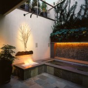 view of the outdoor entertainment area featuring tiled architecture, backyard, courtyard, daylighting, estate, home, house, interior design, landscape lighting, lighting, outdoor structure, patio, property, real estate, sunlight, wall, window, black