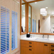 view of the bathroom featuring rift oak cabinetry, bathroom, bathroom accessory, bathroom cabinet, cabinetry, countertop, home, interior design, kitchen, room, window, gray, brown