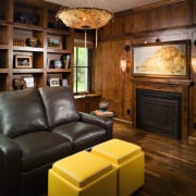 Image of lounge, featuring a fireplace, leather couches fireplace, flooring, furniture, hardwood, home, interior design, living room, room, wall, wood, wood burning stove, wood flooring, brown, black