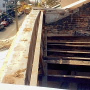 A exterior view of the apartment before it handrail, roof, stairs, wall, wood, black