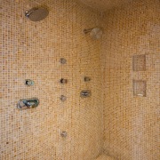 A view of the Shower featuring mosaic tiled ceiling, floor, flooring, room, tile, wall, wood, brown, orange