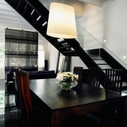 The architects chose a black-and-white theme to unify ceiling, dining room, furniture, interior design, light fixture, lighting, table, black, gray