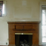 A view of the home before it was fireplace, floor, flooring, hardwood, hearth, home, wall, brown