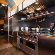 A view of this contemporary kitchen featuring polished cabinetry, countertop, cuisine classique, interior design, kitchen, black, brown