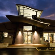 A view of the Papamoa Library constructed by architecture, building, evening, home, house, lighting, reflection, sky, brown, blue
