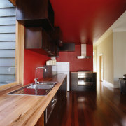 A view of the kitchen area, wooden flooring, architecture, cabinetry, ceiling, countertop, floor, flooring, hardwood, house, interior design, kitchen, laminate flooring, real estate, room, wood, wood flooring, red