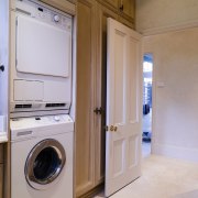 Interior view of laundry featuring Miele washing machine cabinetry, clothes dryer, floor, home appliance, laundry, laundry room, major appliance, room, washing machine, gray, brown