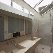 A view of the bathrom featuring tiled walls/flooring, architecture, bathroom, daylighting, glass, interior design, room, sink, gray