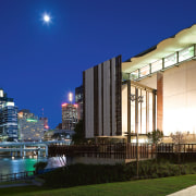 A view of the two buildings which form architecture, building, city, cityscape, condominium, corporate headquarters, downtown, evening, hotel, lighting, metropolis, metropolitan area, mixed use, night, real estate, reflection, sky, skyline, skyscraper, urban area, water, blue