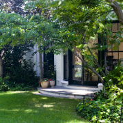 An exterior view of the house and its backyard, cottage, courtyard, estate, garden, grass, home, house, landscape, landscaping, lawn, neighbourhood, outdoor structure, plant, property, real estate, residential area, tree, yard, green