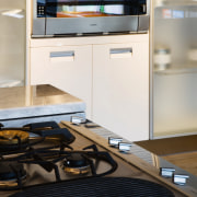 A close up view of a cooktop. - countertop, floor, flooring, furniture, home appliance, kitchen, product design, white, black