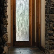 Entrance way with stone tile flooring and wall, door, home, structure, wall, window, wood, black, brown
