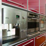 A close up view of an Omega Smeg cabinetry, countertop, glass, home appliance, interior design, kitchen, red
