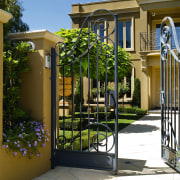 A view of this  Mediteranean style house courtyard, estate, facade, fence, gate, home, house, neighbourhood, outdoor structure, property, real estate, residential area, brown