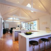 A view of the kitchen featuring stained timber beam, ceiling, countertop, daylighting, floor, flooring, interior design, kitchen, real estate, room, gray, orange