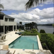 A view of some swimming pool grates. - arecales, condominium, estate, home, hotel, house, leisure, palm tree, property, real estate, resort, sea, sky, swimming pool, vacation, villa, water, gray