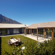 A view of a home by Fletcher Living. cottage, elevation, estate, facade, farmhouse, home, house, landscape, mountain, property, real estate, roof, sky, villa, brown