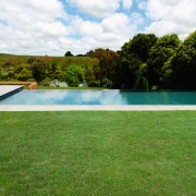 A view of a swimming pool by Pleasure area, backyard, estate, grass, house, lawn, leisure, plant, property, real estate, swimming pool, villa, water, yard, green, white