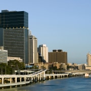 View of the 40 storey brisbane square building bridge, building, city, cityscape, condominium, daytime, downtown, metropolis, metropolitan area, real estate, reflection, river, sky, skyline, skyscraper, tower block, urban area, water, teal