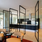 A view of this lounge and kitchen featuring ceiling, floor, flooring, interior design, living room, real estate, window, gray