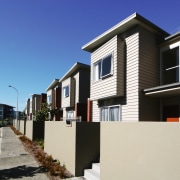 An exterior view of this new residential complex apartment, architecture, building, condominium, elevation, facade, home, house, neighbourhood, property, real estate, residential area, siding, suburb, window, white, black