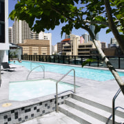 A view of the outdoor pool at the architecture, condominium, outdoor furniture, outdoor structure, property, real estate, residential area, tree, urban design, walkway, water, white, black