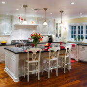 A view of this kitchen featuring white timber cabinetry, countertop, cuisine classique, dining room, floor, flooring, hardwood, interior design, kitchen, room, wood flooring, gray