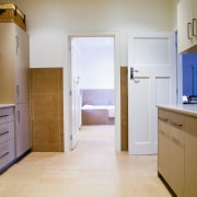 View of a large laundry which features cabinetry, cabinetry, countertop, floor, flooring, hardwood, home, home appliance, interior design, kitchen, real estate, room, wood, wood flooring, gray, brown