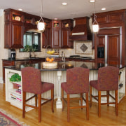 A view of this kitchen featuring custom cherry cabinetry, countertop, cuisine classique, dining room, floor, flooring, hardwood, home, interior design, kitchen, laminate flooring, real estate, room, wood flooring, brown, gray