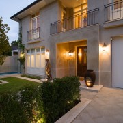 An exterior view of the entrance way of apartment, building, estate, facade, home, house, lighting, property, real estate, residential area, villa, window, gray, brown