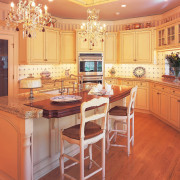 A view of this kitchen featuring traditional colonial cabinetry, countertop, cuisine classique, dining room, floor, flooring, hardwood, home, interior design, kitchen, room, wall, wood, wood flooring, orange