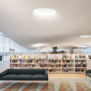 Natural light contributes to the relaxed, healthy ambience architecture, bookcase, building, ceiling, coffee table, couch, design, floor, flooring, furniture, home, house, interior design, lighting, living room, loft, property, real estate, room, shelf, shelving, table, gray