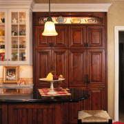 View of this traditional designed kitchen featuring granite cabinetry, countertop, cuisine classique, dining room, furniture, interior design, kitchen, room, shelving, table, wall, window, red