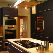 A view of this kitchen features cabinets by cabinetry, countertop, interior design, kitchen, room, black, brown